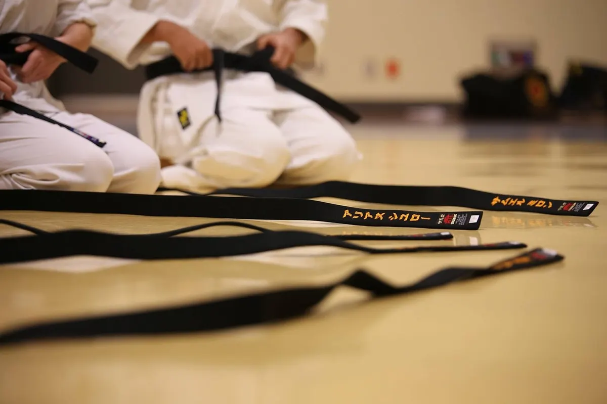 Černé pásky karate položené na tatami